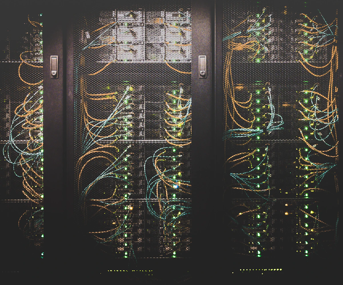 Fibre patch cabling running through a dark server cabinet.